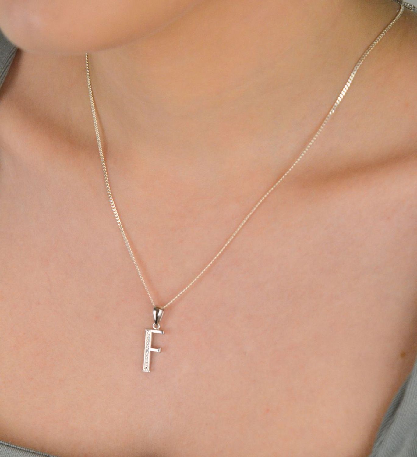 Zawieszka literka F z cyrkoniami próba 925, AP17-0213 F Zawieszka w kształcie literki „F” ozdobiona cyrkoniami to elegancka i subtelna biżuteria wykonana z wysokiej jakości srebra próby 925. 1.jpg